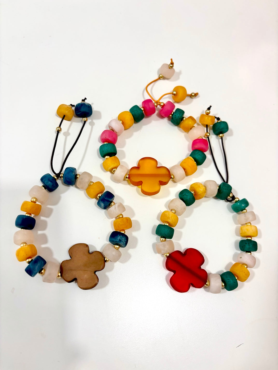 Pulseras elásticas multicolor con flor central ámbar, marrón y roja
